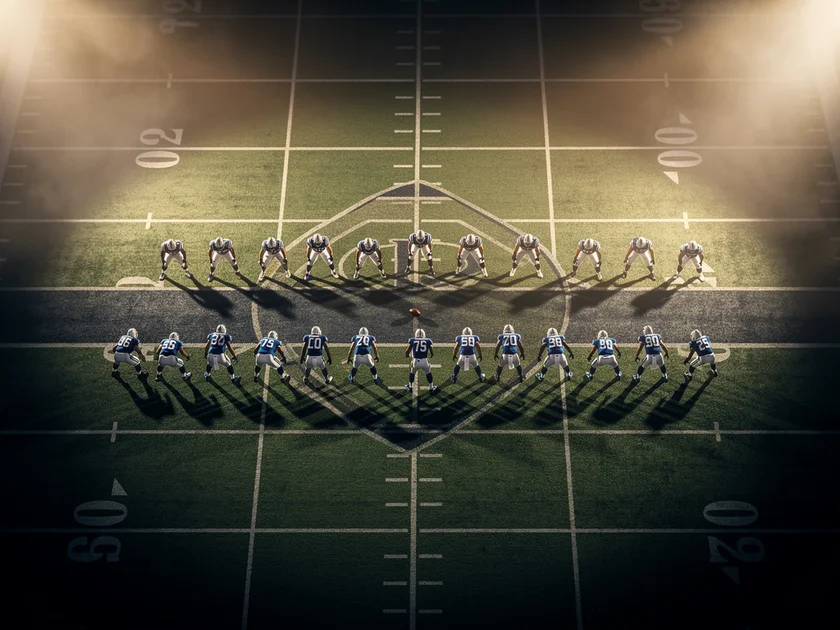 NFL team helmets arranged around a Fantasy Football draft board showing 2026 salary cap figures