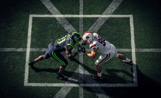 College football players on the field representing the NCAA Football NIL era competitive shift in 20