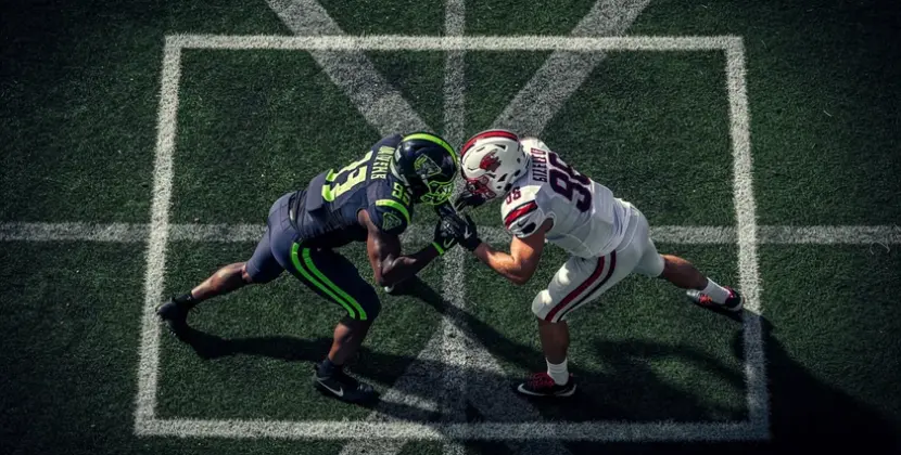 College football players on the field representing the NCAA Football NIL era competitive shift in 20