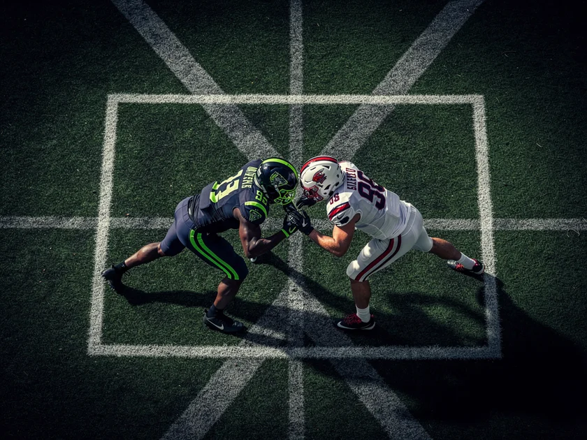 College football players on the field representing the NCAA Football NIL era competitive shift in 20